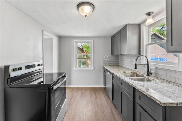 1202 E 23rd St S, Independence, MO 64055 - kitchen featuring appliances with stainless steel finishes, gray cabinets, tasteful backsplash, and light wood-style floors