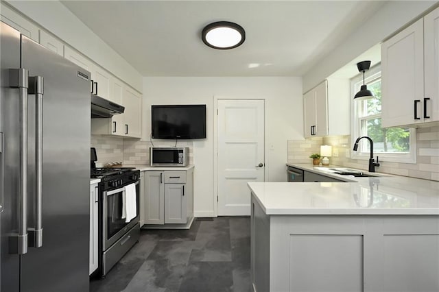 6217 Glenwood St, Mission, KS 66202 - kitchen with stainless steel appliances, under cabinet range hood, light countertops, and a peninsula