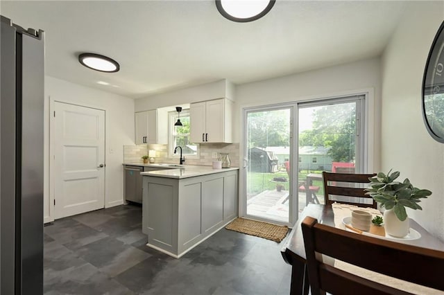 6217 Glenwood St, Mission, KS 66202 - kitchen with appliances with stainless steel finishes, a peninsula, light countertops, tasteful backsplash, and white cabinetry