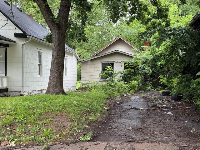 2720 Lister Ave, Kansas City, MO 64128 - view of side of home with a shingled roof and a chimney