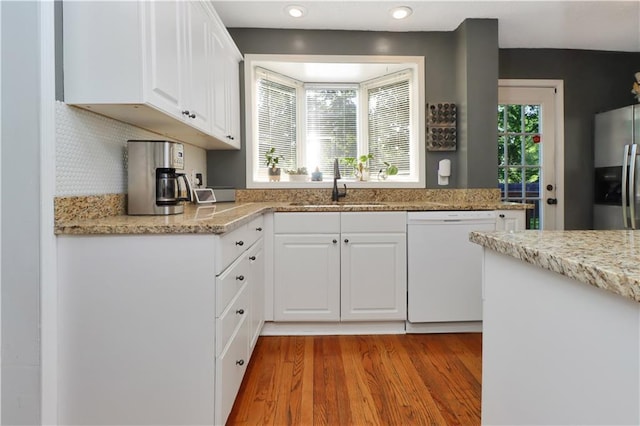 5217 Birch St, Roeland Park, KS 66205 - kitchen with dishwasher, stainless steel fridge with ice dispenser, white cabinets, light wood-style flooring, and light stone counters