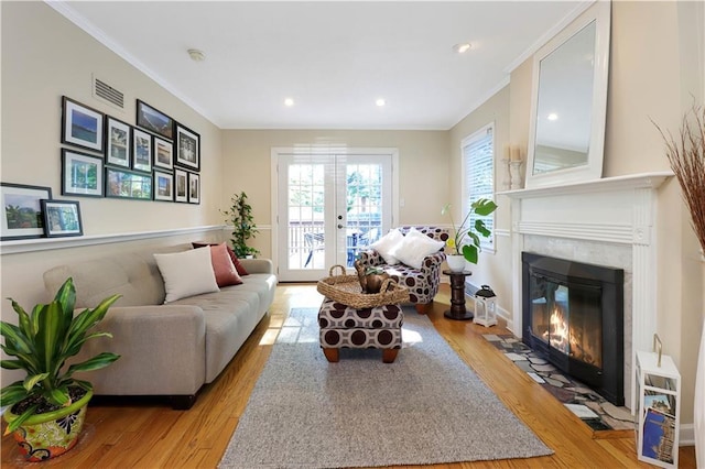 5217 Birch St, Roeland Park, KS 66205 - living area featuring crown molding, light wood-type flooring, a fireplace, recessed lighting, and french doors