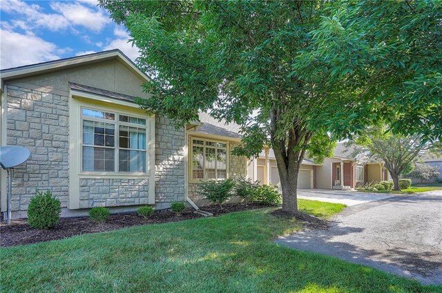 15730 S Brentwood St Unit 2602, Olathe, KS 66062 - view of front of home featuring stone siding, a garage, driveway, and a front lawn