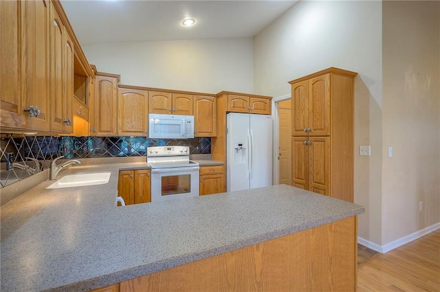 15730 S Brentwood St Unit 2602, Olathe, KS 66062 - kitchen with white appliances, high vaulted ceiling, backsplash, light wood-style floors, and a peninsula