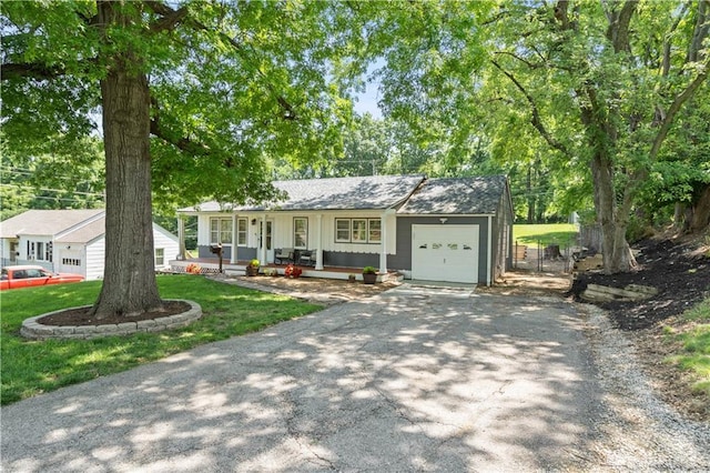 7801 W 55th Ter, Overland Park, KS 66202 - ranch-style home featuring a porch, asphalt driveway, an attached garage, and a front lawn