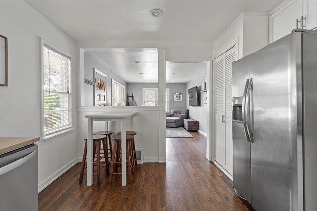 7801 W 55th Ter, Overland Park, KS 66202 - kitchen with appliances with stainless steel finishes, dark wood finished floors, white cabinetry, a breakfast bar, and open floor plan