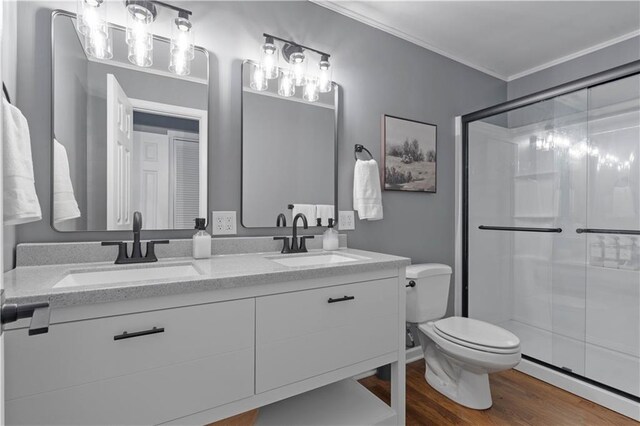 7801 W 55th Ter, Overland Park, KS 66202 - full bathroom featuring double vanity, a stall shower, wood finished floors, ornamental molding, and a baseboard radiator