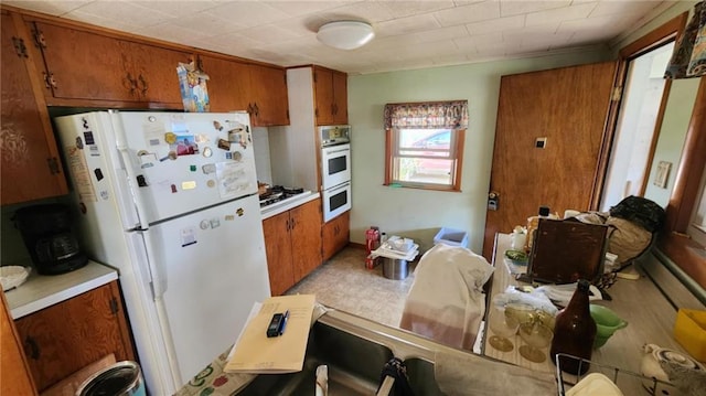304 N Mckinley St, Weir, KS 66781 - kitchen with white appliances, brown cabinetry, and light countertops