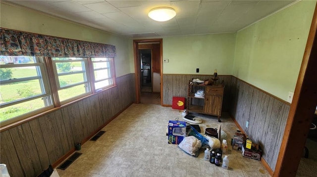 304 N Mckinley St, Weir, KS 66781 - unfurnished room featuring a wainscoted wall, wooden walls, ornamental molding, and light flooring