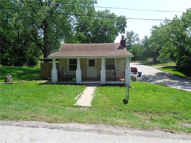 11401 E Scarritt Ave, Sugar Creek, MO 64054 - bungalow-style home featuring covered porch, a chimney, and a front lawn