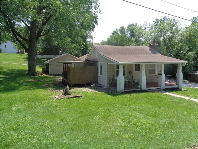 11401 E Scarritt Ave, Sugar Creek, MO 64054 - bungalow featuring a porch, a chimney, a front yard, and a shingled roof