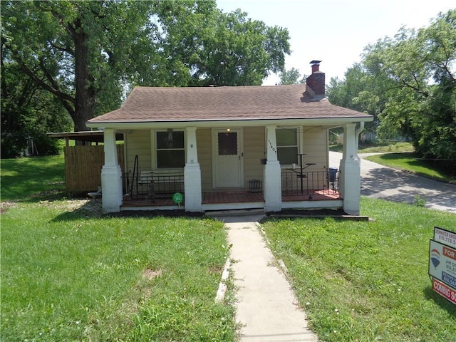 11401 E Scarritt Ave, Sugar Creek, MO 64054 - bungalow-style house with covered porch, a chimney, and a front yard