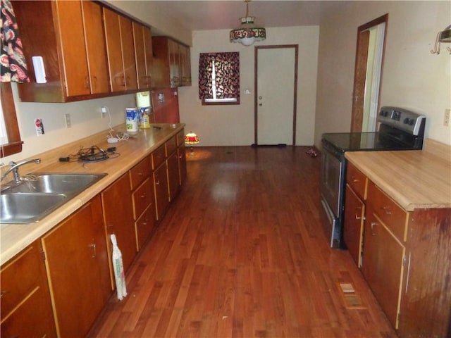 11401 E Scarritt Ave, Sugar Creek, MO 64054 - kitchen featuring stainless steel electric range oven, brown cabinetry, and wood finished floors
