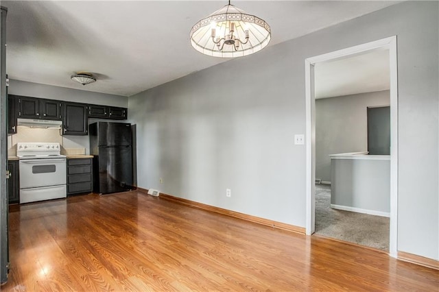 508 NE Shiloh Cir, Blue Springs, MO 64014 - kitchen featuring electric range, freestanding refrigerator, a chandelier, wood finished floors, and under cabinet range hood