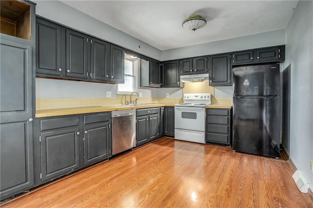 508 NE Shiloh Cir, Blue Springs, MO 64014 - kitchen with freestanding refrigerator, electric stove, stainless steel dishwasher, under cabinet range hood, and light countertops