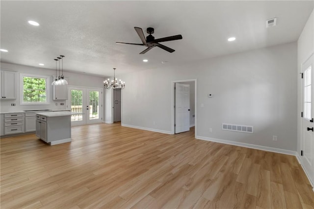 410 E Main St, Richmond, MO 64085 - unfurnished living room featuring french doors, a ceiling fan, recessed lighting, light wood-style flooring, and a chandelier