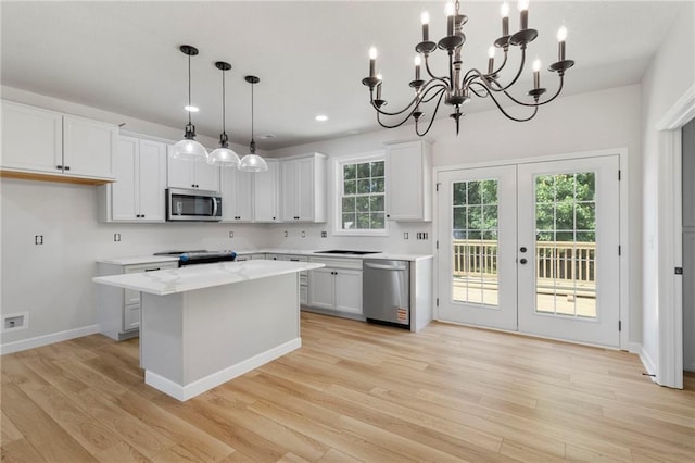 410 E Main St, Richmond, MO 64085 - kitchen featuring stainless steel appliances, light wood-style floors, a kitchen island, french doors, and white cabinetry