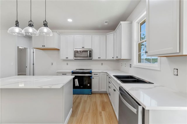 410 E Main St, Richmond, MO 64085 - kitchen with appliances with stainless steel finishes, light wood finished floors, white cabinets, pendant lighting, and recessed lighting