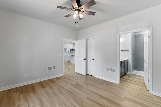 410 E Main St, Richmond, MO 64085 - unfurnished bedroom with light wood-style floors, ensuite bathroom, ceiling fan, and a closet