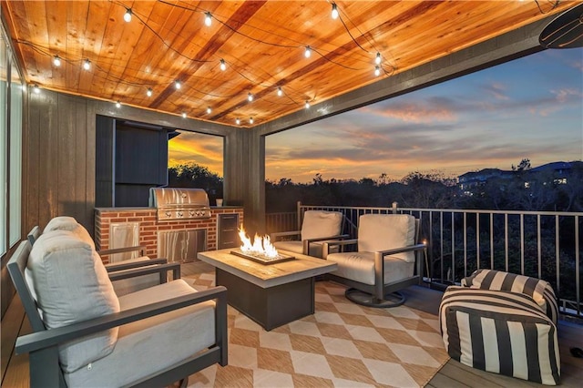11594 S Zarda Dr, Olathe, KS 66061 - patio terrace at dusk with an outdoor kitchen, a patio, and an outdoor living space with a fire pit