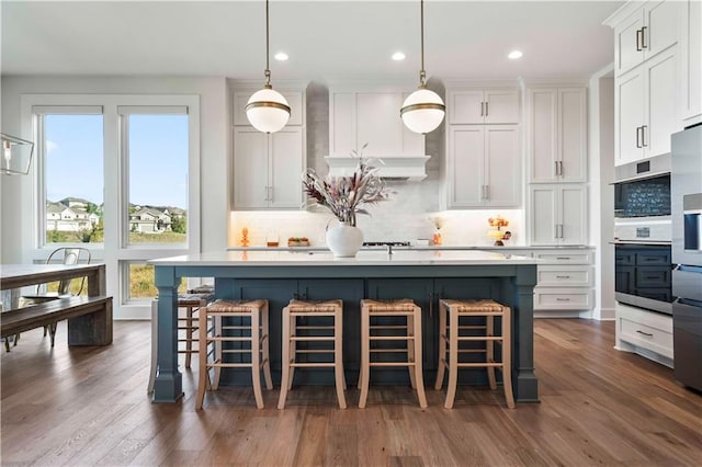 11594 S Zarda Dr, Olathe, KS 66061 - kitchen featuring white cabinetry, tasteful backsplash, light countertops, a kitchen island with sink, and recessed lighting
