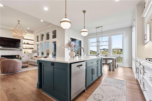 11594 S Zarda Dr, Olathe, KS 66061 - kitchen featuring stainless steel dishwasher, a chandelier, light countertops, a center island with sink, and white cabinets