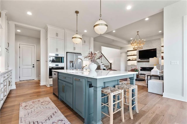11594 S Zarda Dr, Olathe, KS 66061 - kitchen with white cabinetry, light wood finished floors, stainless steel refrigerator with ice dispenser, recessed lighting, and a kitchen breakfast bar