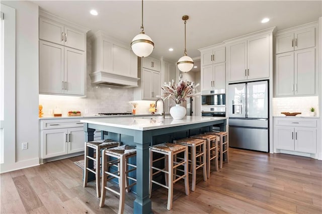 11594 S Zarda Dr, Olathe, KS 66061 - kitchen with stainless steel refrigerator with ice dispenser, decorative backsplash, light countertops, recessed lighting, and light wood finished floors