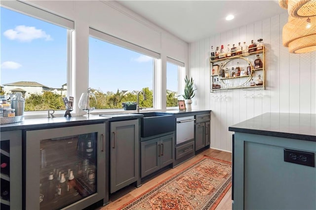 11594 S Zarda Dr, Olathe, KS 66061 - bar with light wood-style floors, beverage cooler, and stainless steel dishwasher