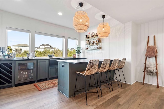 11594 S Zarda Dr, Olathe, KS 66061 - indoor bar with beverage cooler, light wood-style flooring, pendant lighting, and recessed lighting