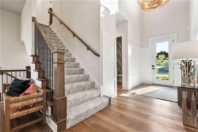11594 S Zarda Dr, Olathe, KS 66061 - foyer featuring a towering ceiling, wood finished floors, stairway, and a chandelier