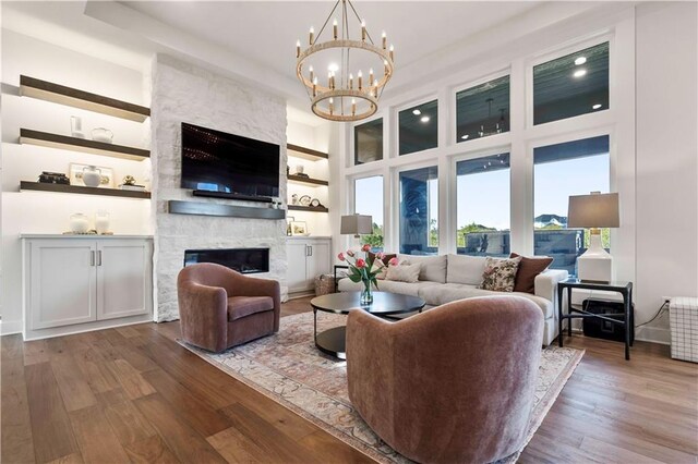 11594 S Zarda Dr, Olathe, KS 66061 - living room with wood finished floors, a fireplace, a chandelier, recessed lighting, and a towering ceiling