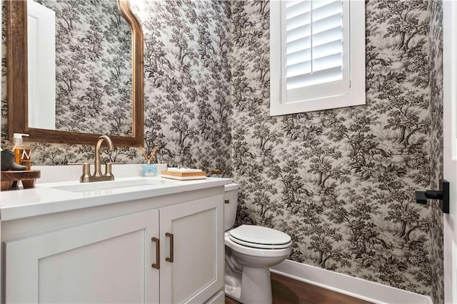 11594 S Zarda Dr, Olathe, KS 66061 - half bath with vanity, wallpapered walls, and wood finished floors