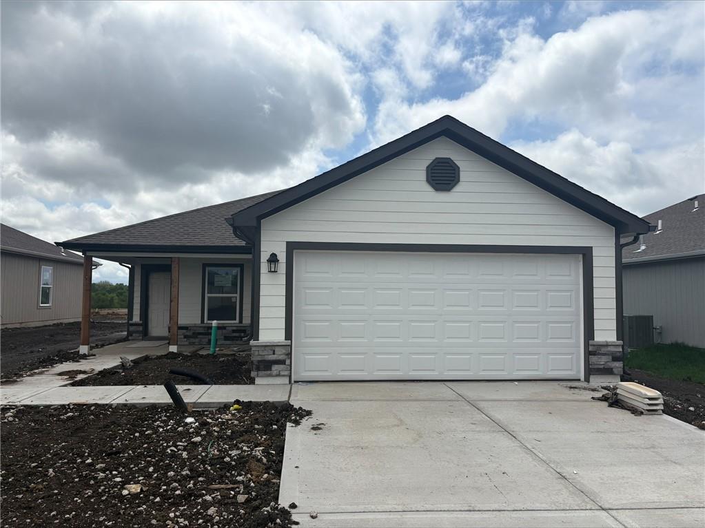 20277 W 194th Ter, St, Spring Hill, KS 66083 - ranch-style home featuring concrete driveway, stone siding, a garage, and covered porch