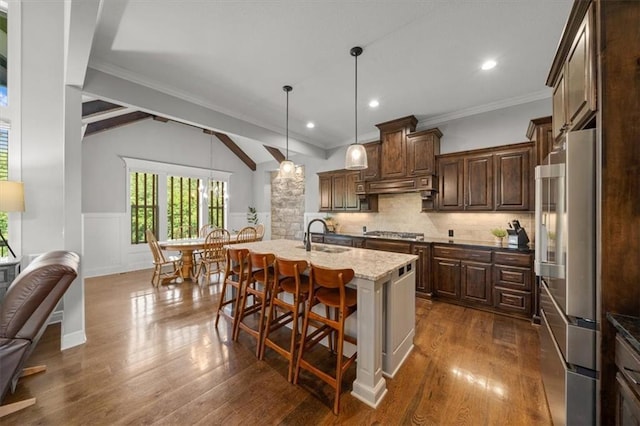 13428 W 172nd St, Overland Park, KS 66221 - kitchen featuring stainless steel appliances, a breakfast bar, a wainscoted wall, dark wood-style floors, and open floor plan