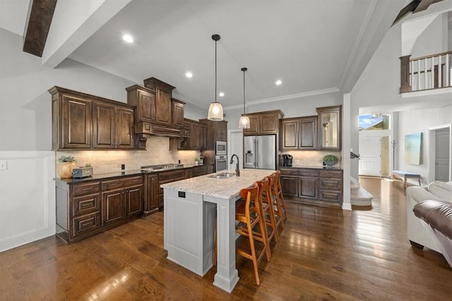 13428 W 172nd St, Overland Park, KS 66221 - kitchen with stainless steel appliances, dark brown cabinetry, crown molding, a kitchen bar, and an island with sink