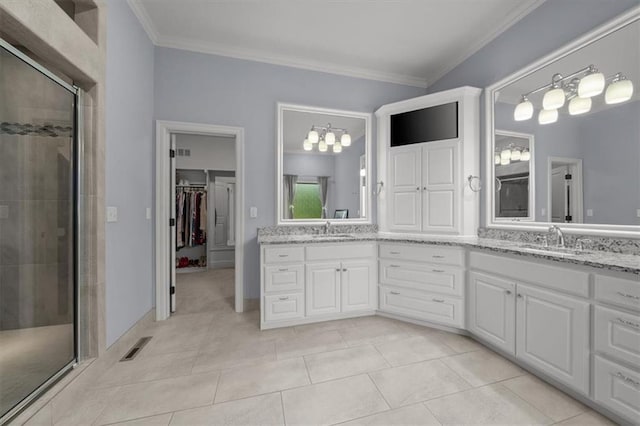 13428 W 172nd St, Overland Park, KS 66221 - bathroom with double vanity, a shower stall, ornamental molding, a walk in closet, and tile patterned flooring