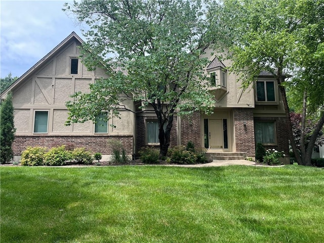 13108 Windsor Cir, Leawood, KS 66209 - tudor home featuring stucco siding, a front lawn, and brick siding
