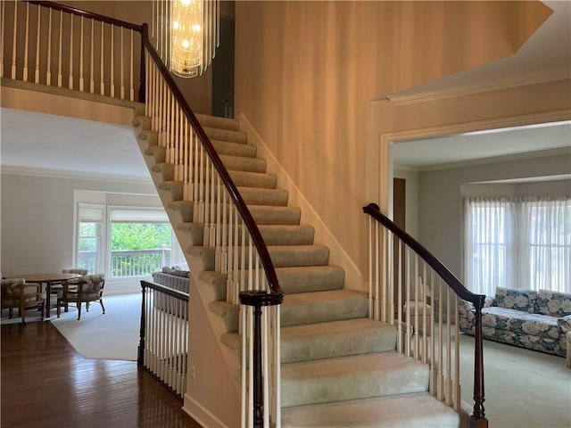 13108 Windsor Cir, Leawood, KS 66209 - stairway featuring crown molding, a chandelier, and wood finished floors