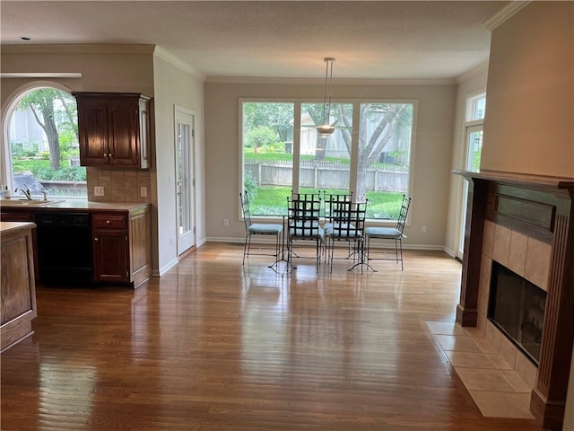 13108 Windsor Cir, Leawood, KS 66209 - dining room featuring dark wood-style floors, a tile fireplace, and ornamental molding