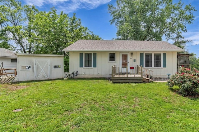 310 E Clay St, Carrollton, MO 64633 - view of front of home featuring board and batten siding, a front yard, and a storage unit