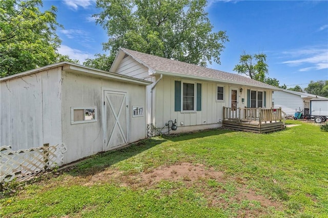 310 E Clay St, Carrollton, MO 64633 - back of house featuring board and batten siding, a yard, and a wooden deck