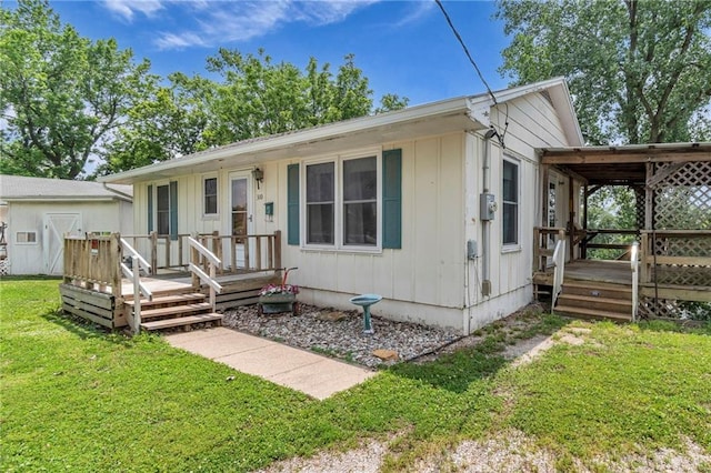 310 E Clay St, Carrollton, MO 64633 - view of front of house featuring a front yard, board and batten siding, and a deck