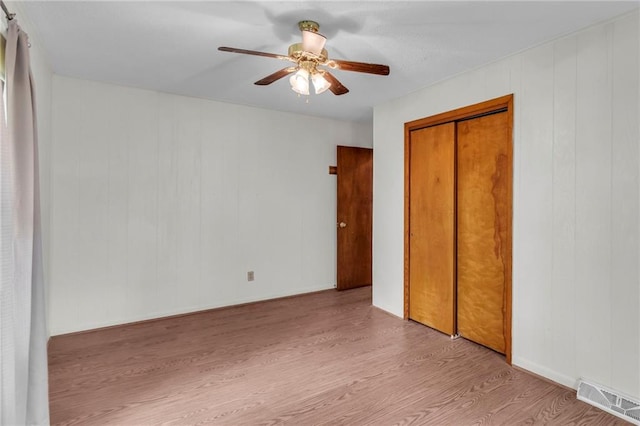 310 E Clay St, Carrollton, MO 64633 - unfurnished bedroom with wood finished floors, a closet, and ceiling fan