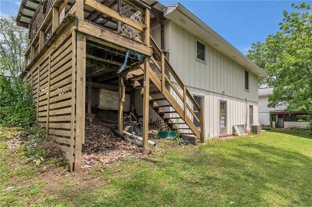 310 E Clay St, Carrollton, MO 64633 - back of property with stairs, a lawn, and a wooden deck