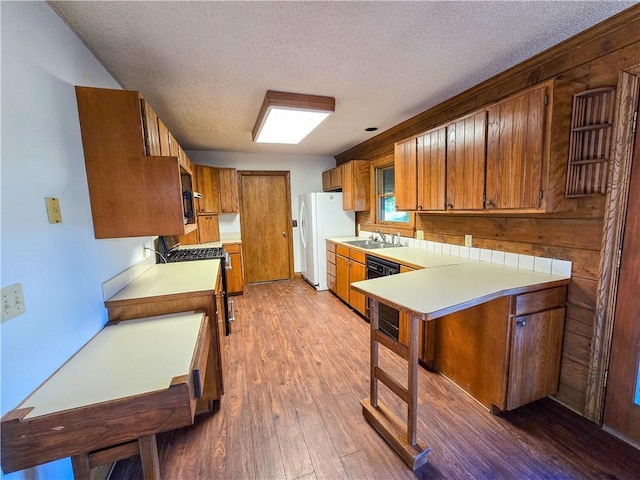 2359 Gp Rd, Ks, KS 66850 - kitchen with freestanding refrigerator, stainless steel range with gas stovetop, brown cabinets, light countertops, and wood finished floors