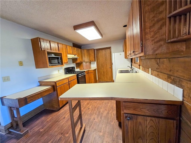 2359 Gp Rd, Ks, KS 66850 - kitchen featuring black appliances, brown cabinetry, light countertops, under cabinet range hood, and a peninsula