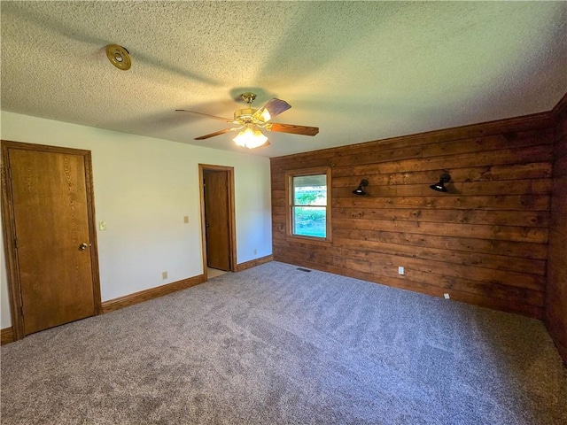 2359 Gp Rd, Ks, KS 66850 - carpeted empty room featuring ceiling fan, a textured ceiling, and wood walls