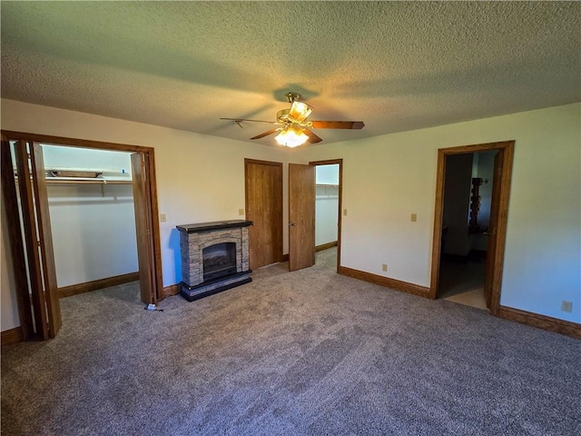 2359 Gp Rd, Ks, KS 66850 - unfurnished living room featuring a ceiling fan, carpet flooring, a stone fireplace, and a textured ceiling