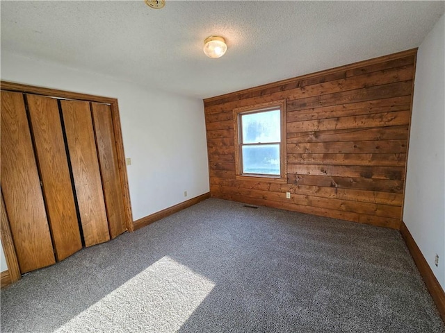 2359 Gp Rd, Ks, KS 66850 - unfurnished bedroom featuring wooden walls, carpet floors, a textured ceiling, and a closet